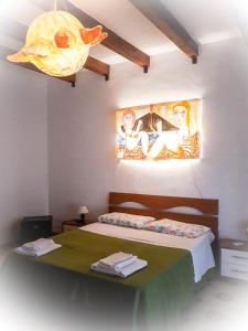 1 dormitorio con 1 cama con una pintura en la pared en Villa il Glicine en Vulcano