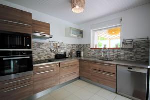 une cuisine avec des placards en bois et des appareils en acier inoxydable dans l'établissement Villa with private pool MQDI53, au Diamant