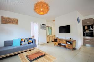 un salon avec un canapé bleu et une télévision dans l'établissement Villa with private pool MQDI53, au Diamant
