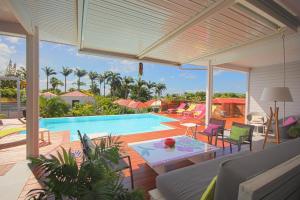 an outdoor patio with a swimming pool and a couch at Villa with private pool SF69 in Saint-François
