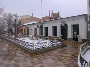 a building on a street with snow on the ground at Rummy Hostal in Uyuni