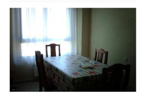 mesa de comedor con mesa, sillas y ventana en Duplex con vistas al mar, en Suances