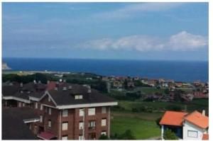 - Vistas a una ciudad con casas y al océano en Duplex con vistas al mar, en Suances