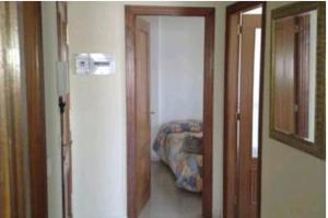 un pasillo con una puerta que da a una habitación con cama en Duplex con vistas al mar, en Suances