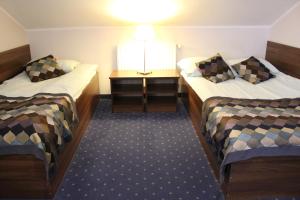 a small room with two beds and a table at Hotel Colnus in Kolno