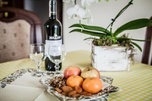 a plate of fruit on a table with a bottle of wine at WILLA BORONIÓWKA Falsztyn nad Jeziorem Czorsztyńskim in Falsztyn