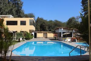 a swimming pool in front of a house at Centro Campestre Qawisqa in Cieneguilla