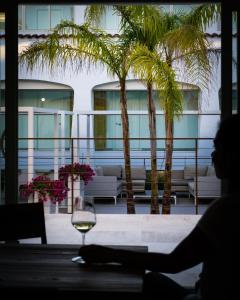 a person sitting at a table with a glass of wine at Hotel San Teodoro in San Teodoro