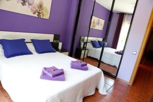 a bedroom with purple walls and a bed with purple towels on it at PISO EXTERIOR COMPLETO A 20 ' DE BARCELONA. in Sabadell