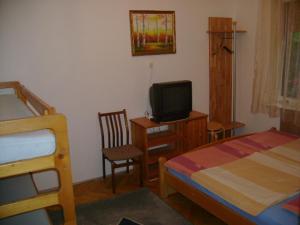 a bedroom with a bed and a desk with a television at Sóstó Apartman in Siófok