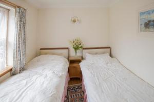 En eller flere senger på et rom på Woodcroft Cottage