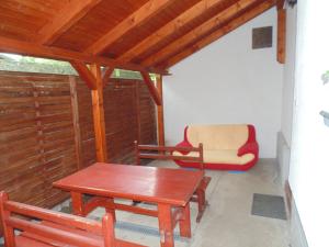a porch with a table and a bench and a chair at Sóstó Apartman in Siófok