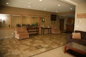 a living room with two chairs and a table at Corporate East Hotel in Ulysses