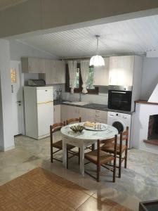 a kitchen with a table and some chairs and a table and a kitchen at Villa Ermilia in Kerveli