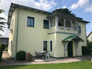 Casa blanca con mesa y sillas en "Villa Seute Deern" Trassenheide, Familie Meutzner, en Trassenheide