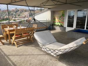 a porch with a hammock and a table and chair at The View Apartments in Yerevan