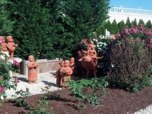 a garden with statues of children in a garden at dover garden suites in Dover