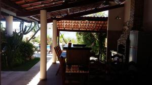 eine Terrasse mit einem Tisch und Stühlen unter einer Pergola in der Unterkunft Hospedaria Chez Nous in Caucaia