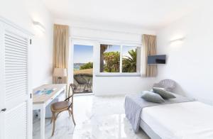 a bedroom with a bed and a desk and a window at B&B Marina Garden in Ischia