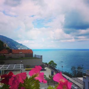 a view of the ocean from a balcony with pink flowers at Hotel Villa Delle Palme in Positano in Positano