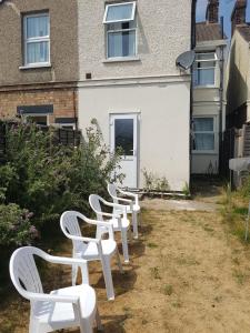 a row of white chairs in front of a building at Wherstead Road House in Ipswich