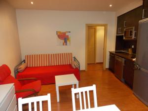 トラマカスティリャ・デ・テナにあるApartamentos Codallosのリビングルーム(赤いソファ付)、キッチン