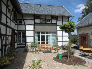 una casa con un banco y una mesa en el patio en Ferienwohnung "im Winkelhof", en Roetgen
