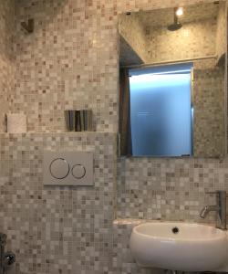 bagno con lavandino e specchio di Coco House Petite Maison a Milano