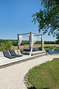 a patio with two lounge chairs and a canopy at Domaine de L'Isle Basse in Fontanes