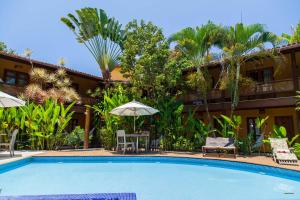 um resort com piscina e cadeiras e um edifício em Pousada Pedra Torta em Itacaré