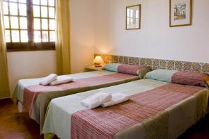 two beds in a hotel room with towels on them at APARTAMENTOS SON BOU Z5 in Son Bou +7 photos