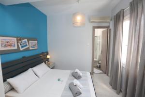 een slaapkamer met een bed en een blauwe muur bij Kini Bay in Kinion