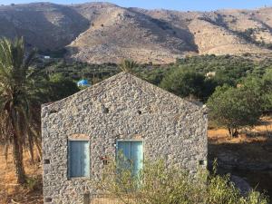 a stone building with two windows on a mountain at "STELIOS & GALINI" in Symi
