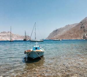 a small boat in the water with other boats at "STELIOS & GALINI" in Symi