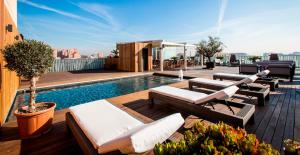 un patio en la azotea con sillas y una piscina en un edificio en Hotel Urpí, en Sabadell
