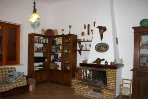 a living room with a fireplace and a couch at La Finestra su Mothia in Marsala +18 photos