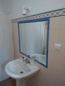 La salle de bains est pourvue d'un lavabo et d'un miroir. dans l'établissement Casa Fatana, à São João dos Caldeireiros