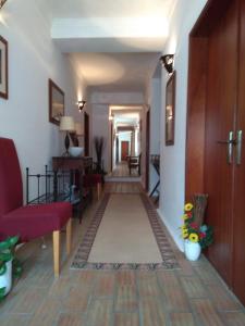 a hallway with a living room with a red couch at Casa Fatana in São João dos Caldeireiros