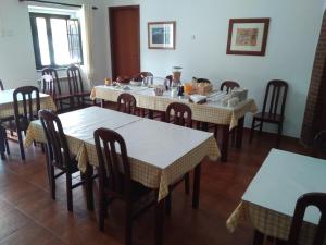 a dining room with tables and chairs in a restaurant at Casa Fatana in São João dos Caldeireiros