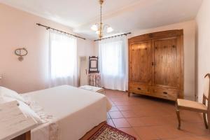 a bedroom with two beds and a wooden cabinet at Appartamento La Terrazza in Lucca