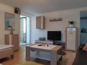ein Wohnzimmer mit einem Tisch und einem TV in der Unterkunft Apartment Upper Town in Gospić