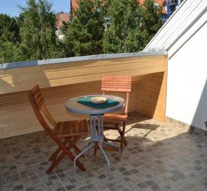 a small patio with a table and two chairs at Pas Virginiją in Nida