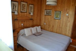 a bedroom with a large bed with wooden walls at Pas Virginiją in Nida