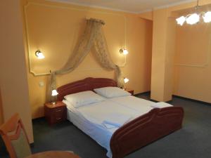 a bedroom with a large bed with a canopy at Hotel Spichlerz in Stargard