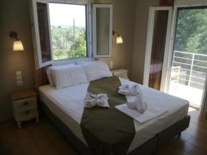 a bedroom with a bed with white towels on it at Rastoni Guest House Skopelos in Skopelos Town