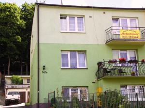 zielony i biały budynek z balkonem w obiekcie Międzyzdrojanka w mieście Międzyzdroje