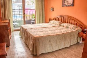 1 dormitorio con 1 cama grande y balcón en Hotel Arillo, en Noja