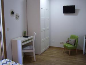 a bedroom with a desk and a green chair at PR Tambre in Santiago de Compostela