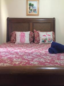 Una cama con almohadas y un libro. en Apartamento Vista da Montanha en Nova Friburgo