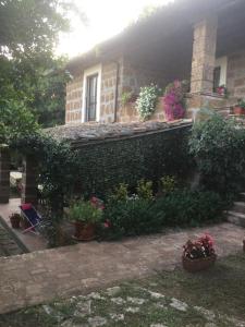 dom z roślinami i kwiatami przed nim w obiekcie Agriturismo Casale Loreto w mieście Corchiano